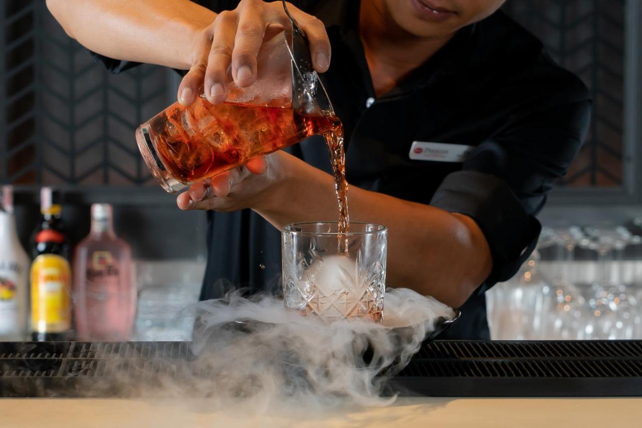 Bayphere Hotel Pattaya Jc Na Chom Thian Esterno foto A bartender pouring a cocktail